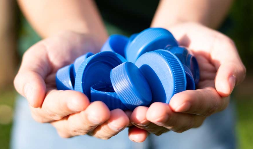 person holding blue bottle caps