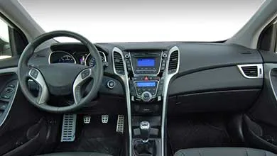 Interior view of a modern vehicle cabin showing dashboard, steering wheel, center console, and front seats.