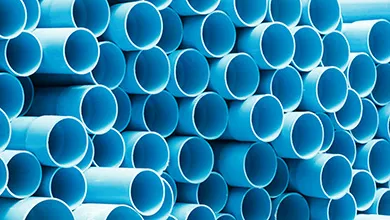 Stacked rows of bright blue hollow cylindrical pipes showing their circular openings.